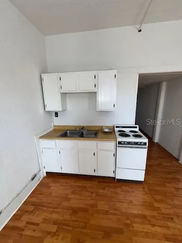 a kitchen with granite countertop white cabinets and white appliances