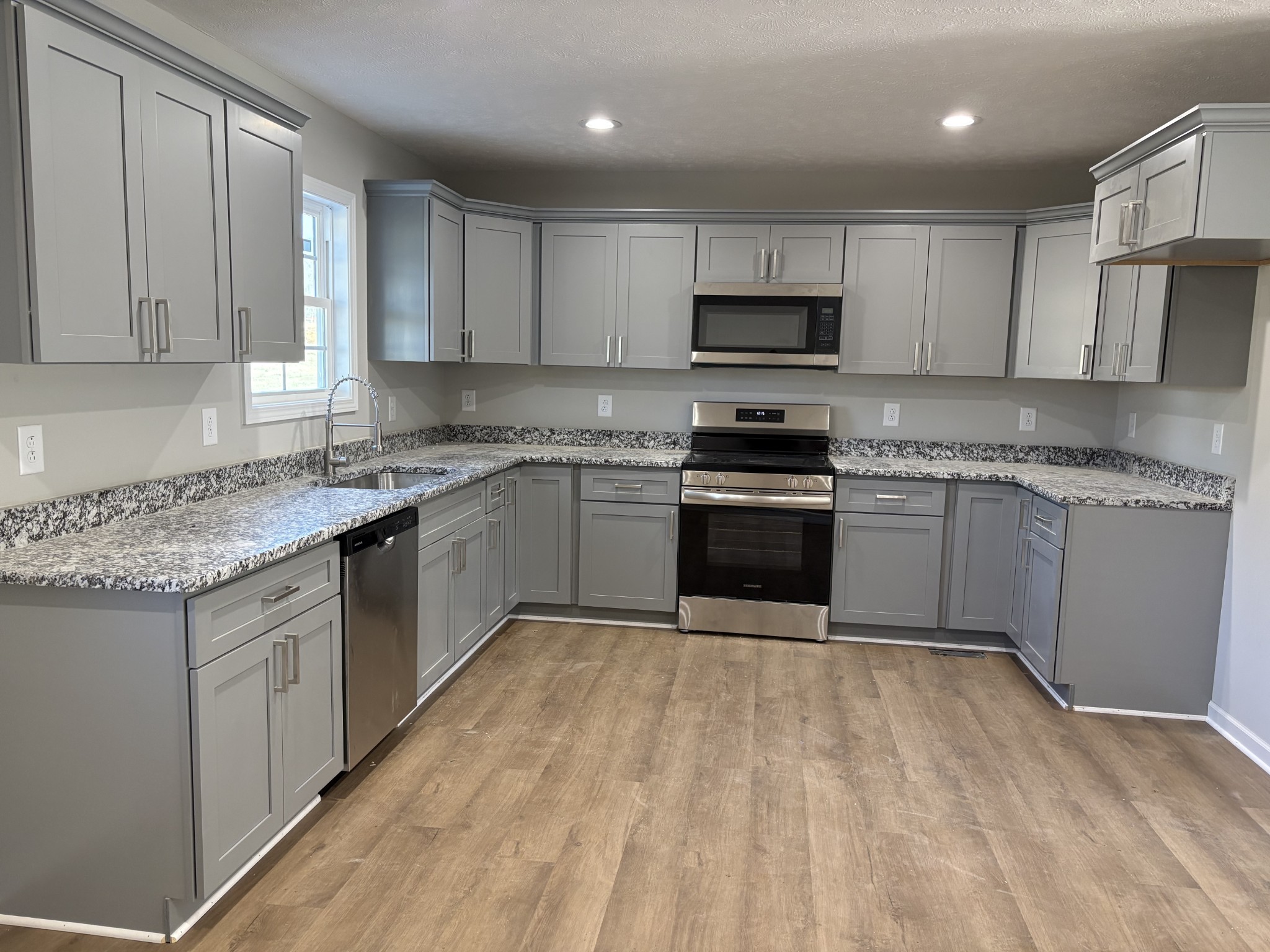 2260 Collier Road Cornersville, TN 37047 - Photo 7 of 15 a kitchen with stainless steel appliances granite countertop a stove a sink dishwasher and a refrigerator