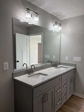 a bathroom with double sink and a mirror