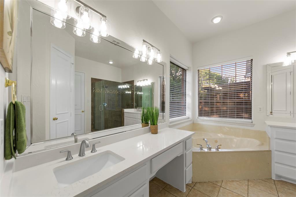 905 Sonora Drive Allen, TX 75013 - Photo 18 of 40 a bathroom with a bathtub a sink and a large mirror