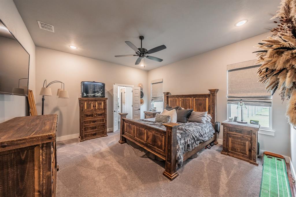 2004 Feather Lane Weatherford, TX 76088 - Photo 12 of 40 a bedroom with a bed chandelier and a large window