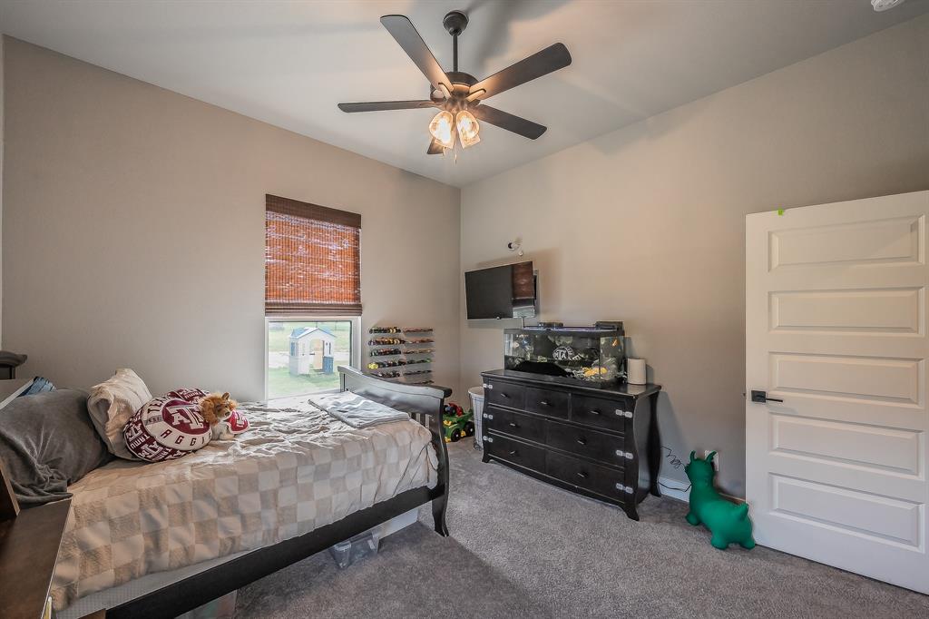 2004 Feather Lane Weatherford, TX 76088 - Photo 21 of 40 a bedroom with a bed and a ceiling fan