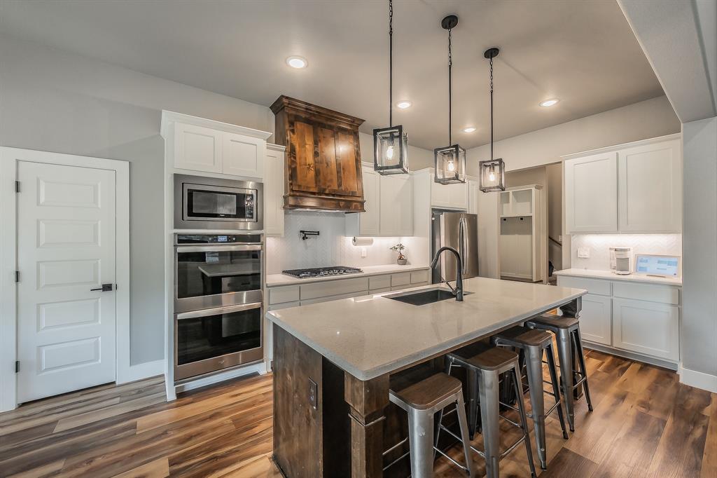 2004 Feather Lane Weatherford, TX 76088 - Photo 7 of 40 a kitchen with kitchen island white cabinets and stainless steel appliances