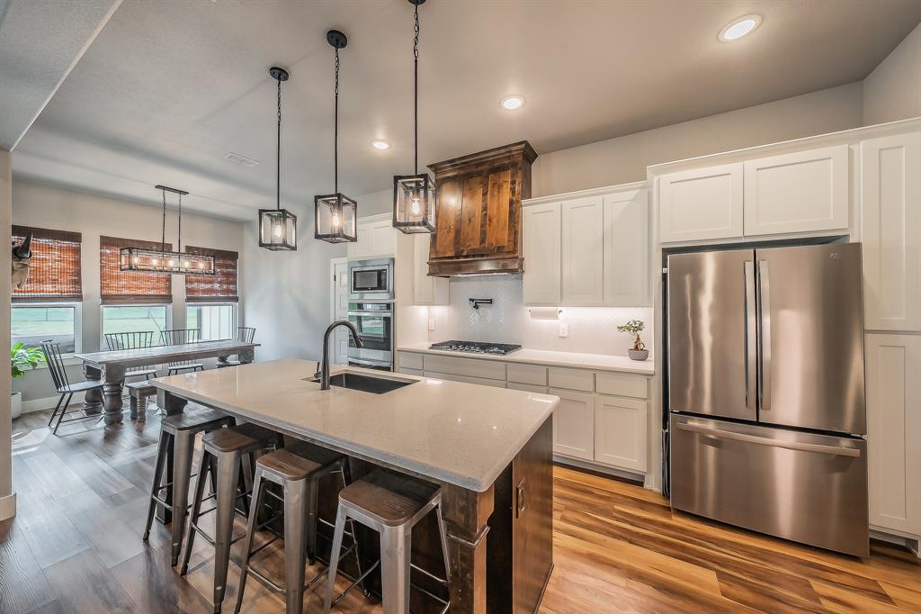 2004 Feather Lane Weatherford, TX 76088 - Photo 8 of 40 a kitchen with kitchen island a refrigerator a stove a table and chairs in it