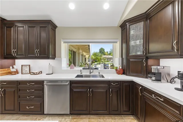 a large kitchen with kitchen island a large counter top and stainless steel appliances
