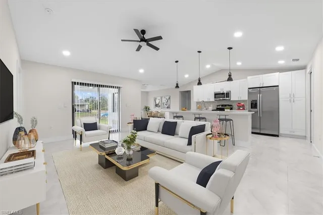 a living room with furniture and kitchen view