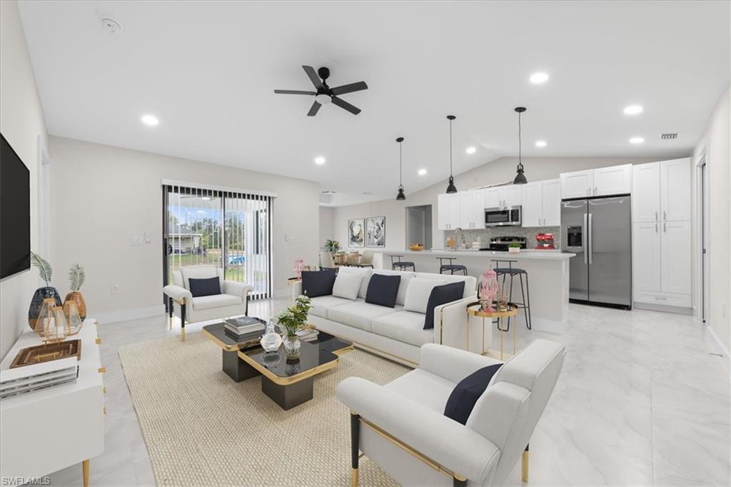 3202 8th Street Southwest Lehigh Acres, FL 33976 - Photo 2 of 21 Living room with vaulted ceiling, a ceiling fan, recessed lighting, and light marble finish flooring
