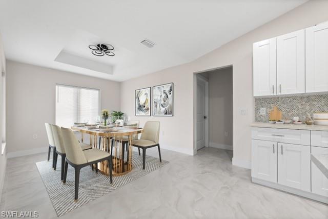 3202 8th Street Southwest Lehigh Acres, FL 33976 - Photo 3 of 21 Dining room featuring a tray ceiling and finished concrete flooring