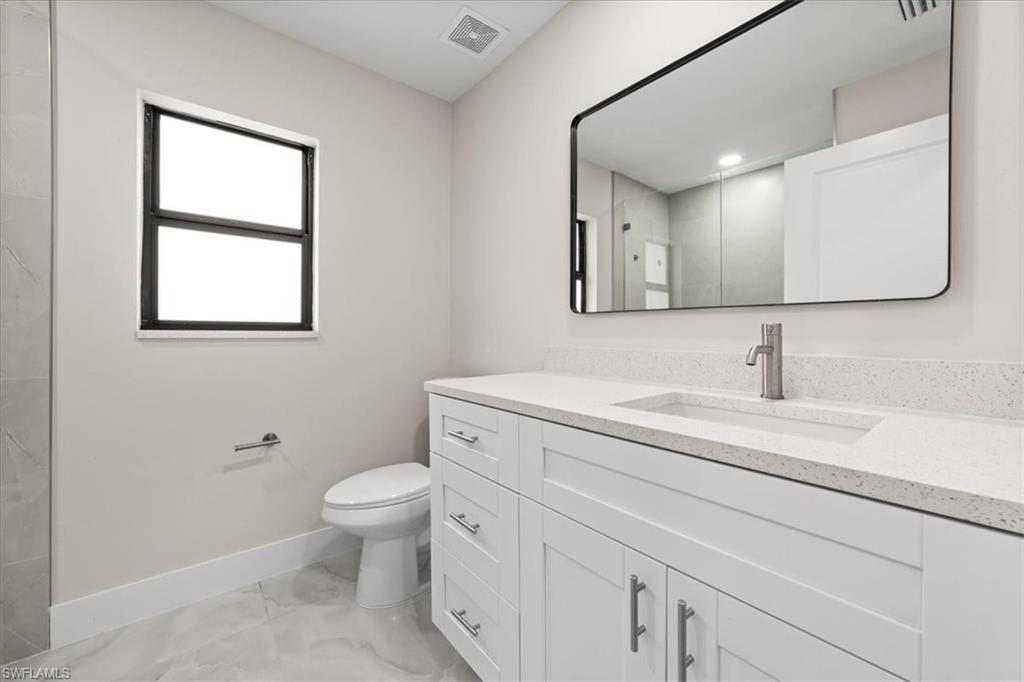 3202 8th Street Southwest Lehigh Acres, FL 33976 - Photo 7 of 21 Guest Bathroom featuring light marble finish flooring and vanity