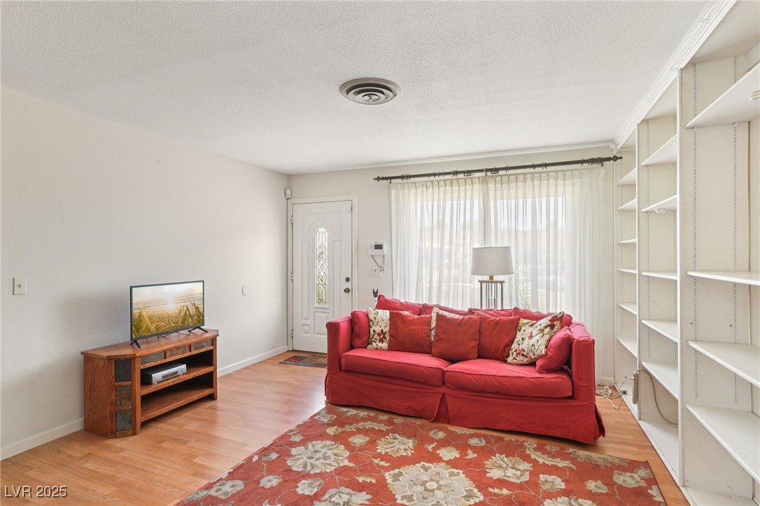 4027 Maple Hill Road Las Vegas, NV 89115 - Photo 6 of 46 Living area with wood finished floors and a textured ceiling