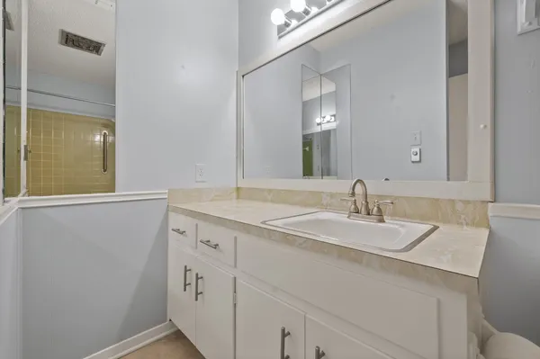 a bathroom with a granite countertop sink and a mirror