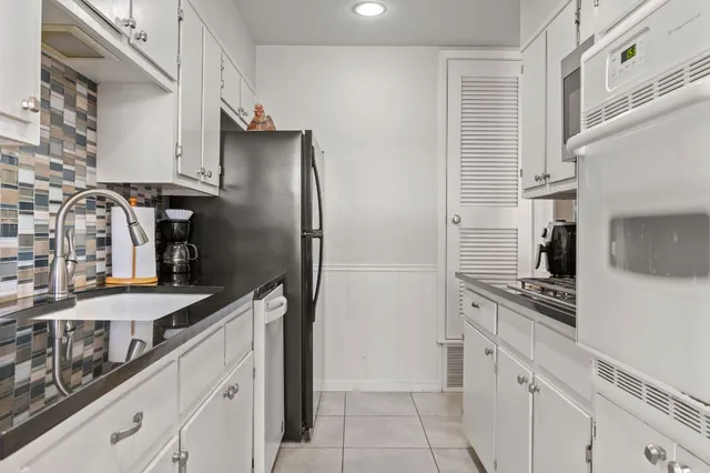 a kitchen with stainless steel appliances granite countertop a refrigerator and a stove