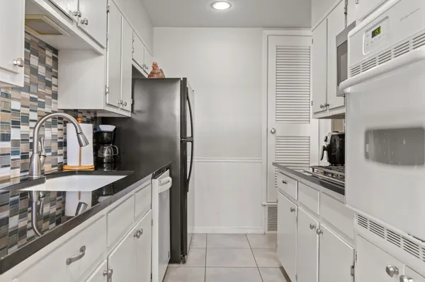 a kitchen with stainless steel appliances granite countertop a refrigerator and a stove