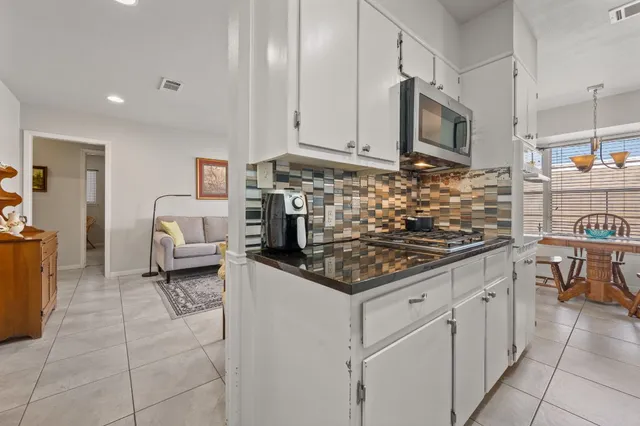 a kitchen with granite countertop a sink and white cabinets