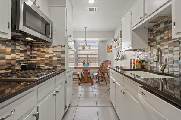 a kitchen with stainless steel appliances granite countertop a sink and cabinets