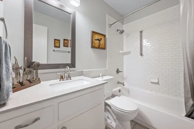 a bathroom with a granite countertop toilet a sink and a bathtub