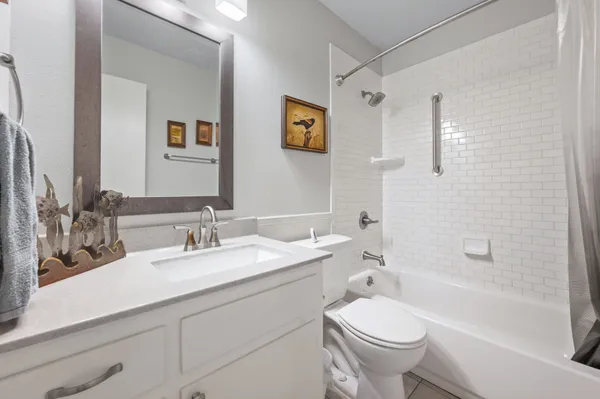 a bathroom with a granite countertop toilet a sink and a bathtub