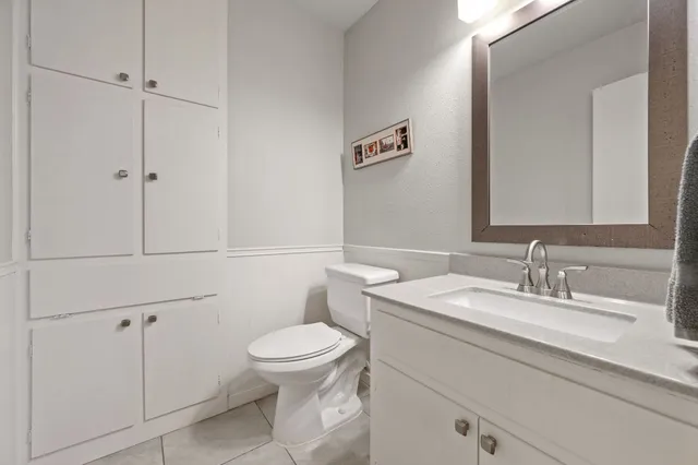 a bathroom with a granite countertop toilet sink mirror and vanity