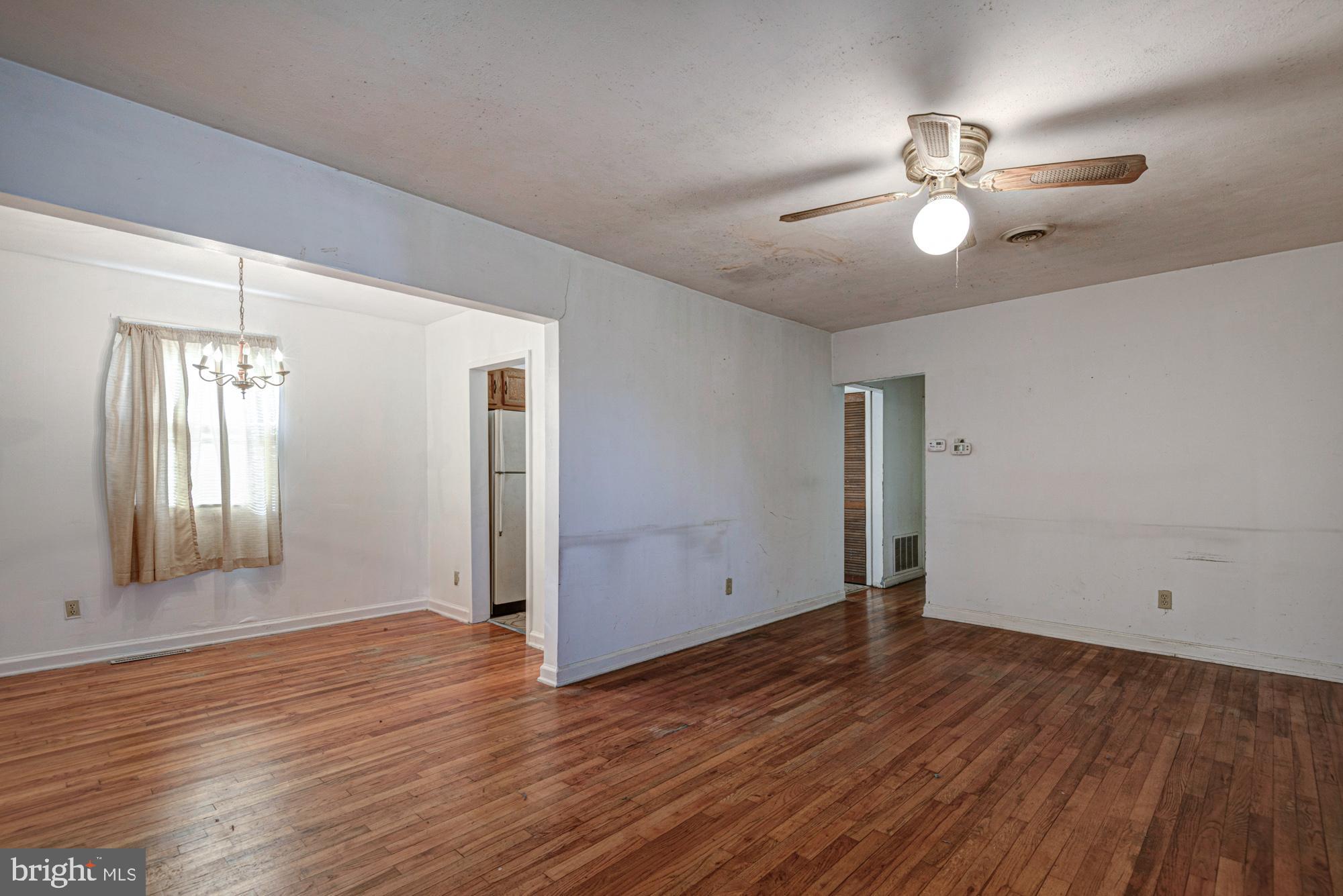 321 Bassett Avenue New Castle, DE 19720 - Photo 14 of 29 an empty room with wooden floor chandelier fan and windows