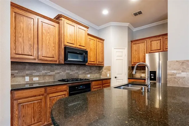 a kitchen with stainless steel appliances granite countertop a stove a sink and a microwave