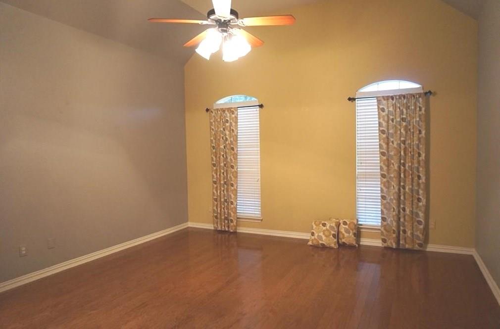 935 Panther Lane Allen, TX 75013 - Photo 16 of 20 an empty room with windows and chandelier fan