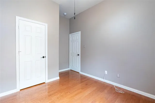 an empty room with wooden floor and closet