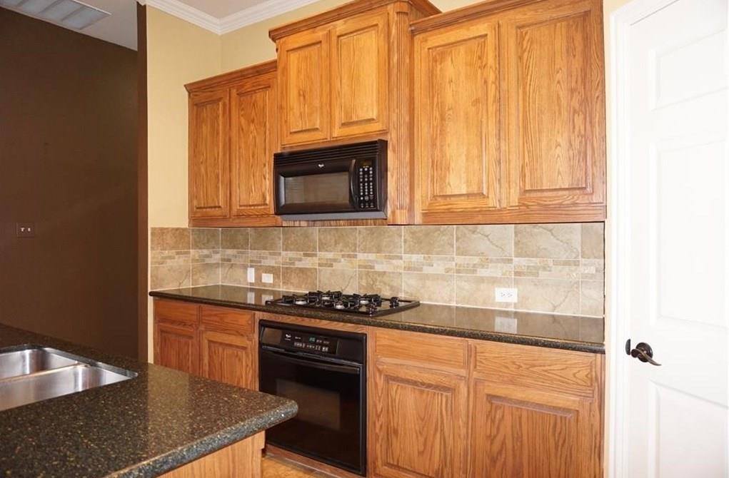 935 Panther Lane Allen, TX 75013 - Photo 10 of 20 a kitchen with granite countertop a stove top oven microwave and cabinets