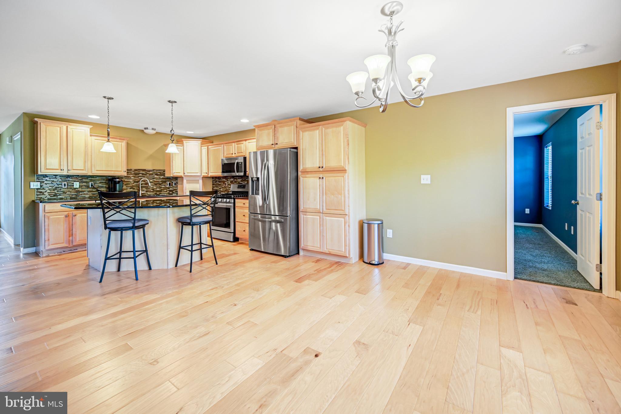 3265 Lewisberry Road York, PA 17404 - Photo 11 of 34 a kitchen with stainless steel appliances kitchen island granite countertop a table chairs stove and refrigerator
