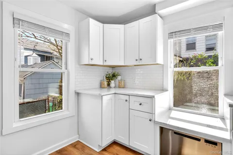 a kitchen with stainless steel appliances white cabinets and a window