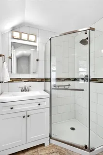 a bathroom with a shower sink and mirror