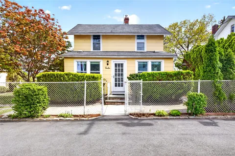 a front view of a house with a garden and plants