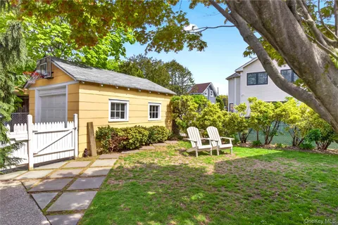 a view of a chair and table in backyard of the house