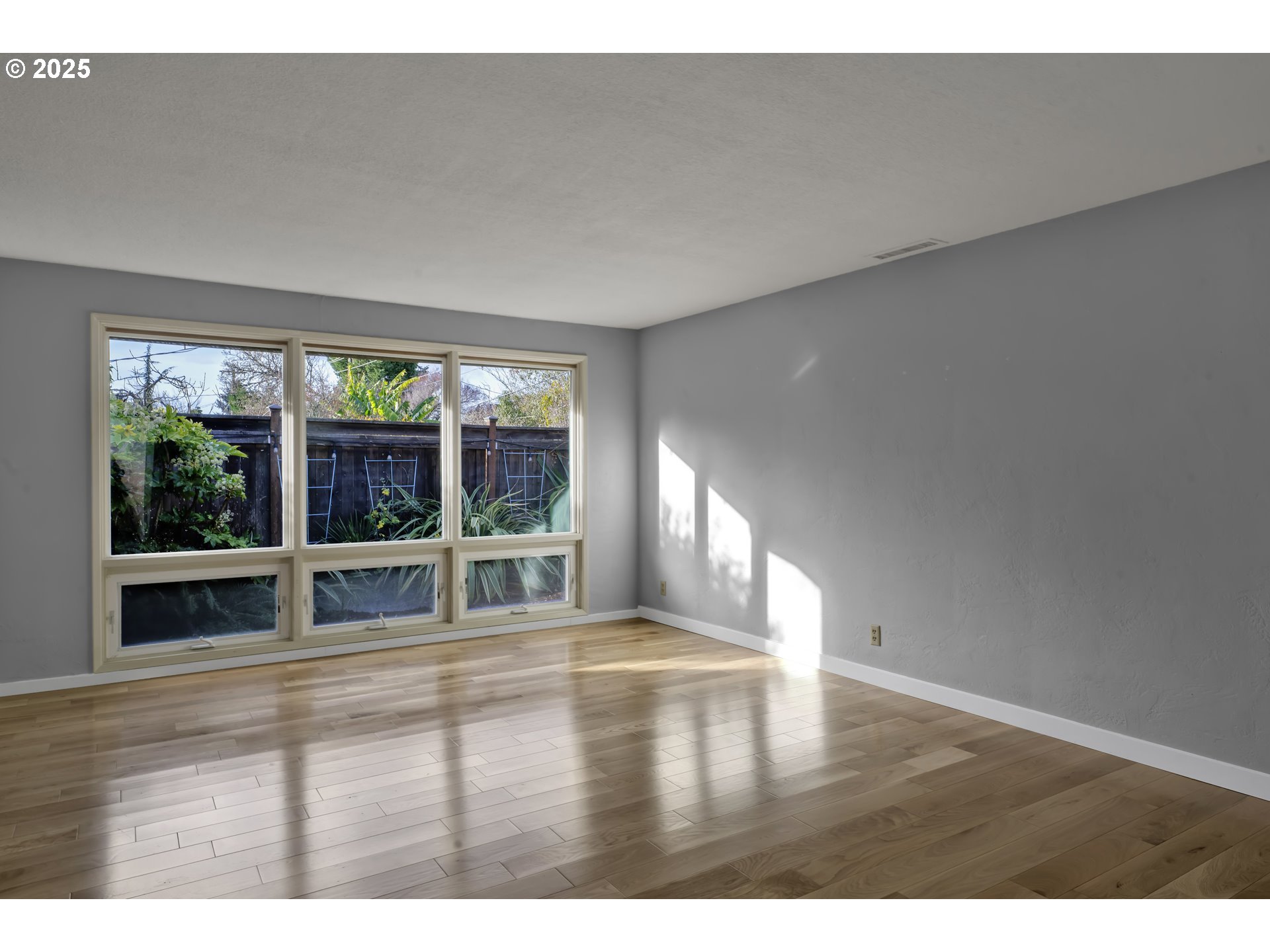 2140 Tabor Street Eugene, OR 97401 - Photo 3 of 26 a view of an empty room with wooden floor and a window