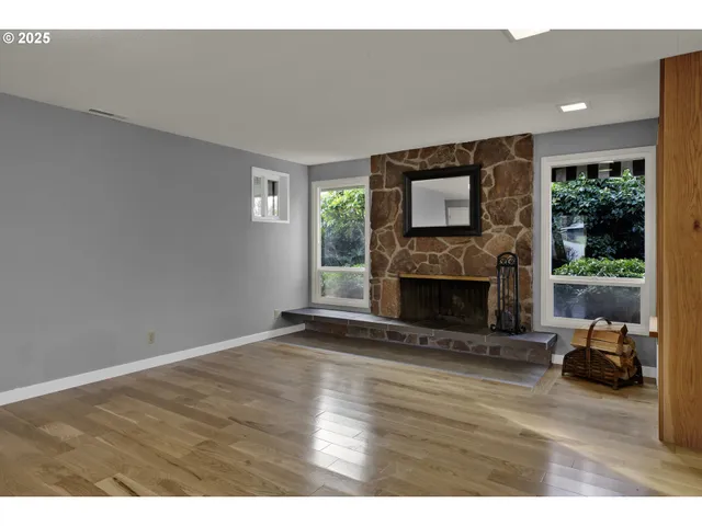 a view of empty room with wooden floor and fireplace