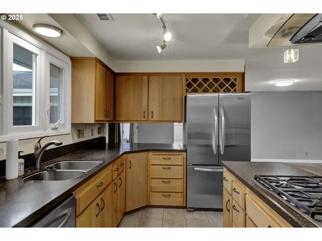 a kitchen with stainless steel appliances granite countertop a refrigerator and a sink