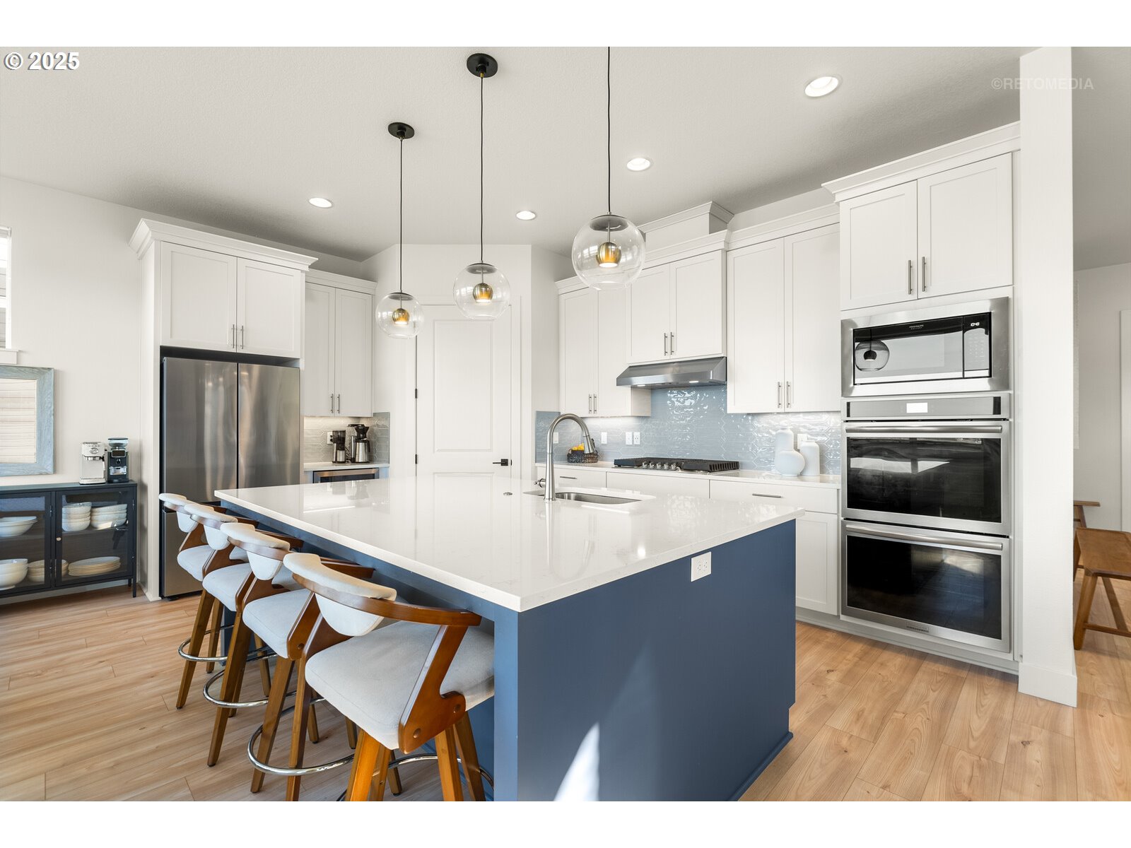 12305 Southwest Silvertip Street Beaverton, OR 97007 - Photo 11 of 43 a kitchen with stainless steel appliances kitchen island a table chairs refrigerator and sink
