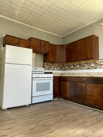 en empty room with wooden floor and windows