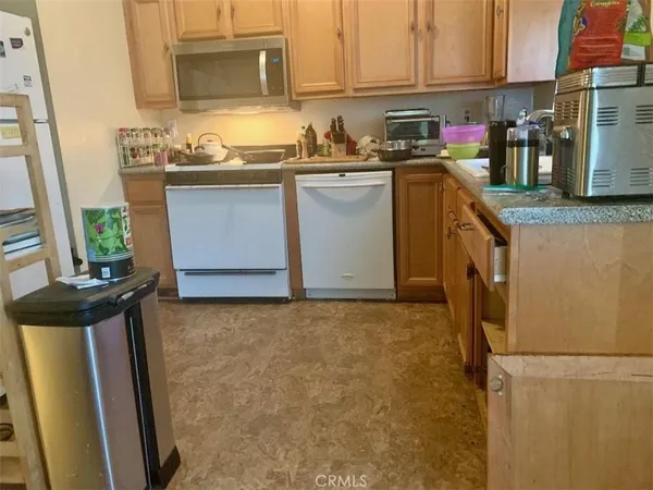 a kitchen with granite countertop a sink stove and refrigerator