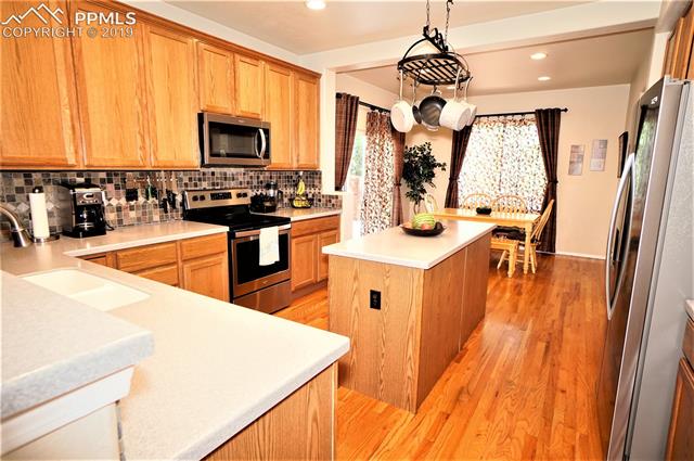 229 Avocet Loop Colorado Springs, CO 80921 - Photo 7 of 34 Hardwood floors in kitchen