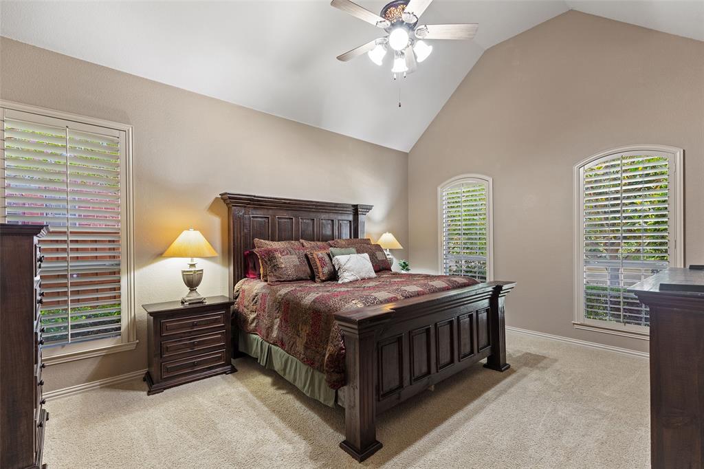 1217 Windmere Way Allen, TX 75013 - Photo 23 of 38 Tucked away for privacy, the serene primary suite features vaulted ceilings and plantation shutters that frame peaceful garden views.