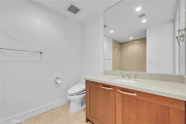 a bathroom with a granite countertop sink a toilet and shower