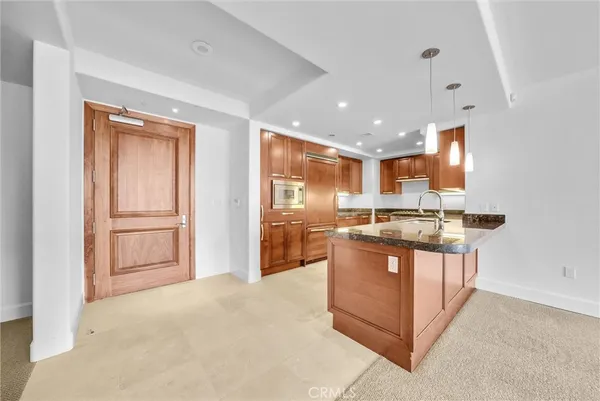 a large kitchen with granite countertop a large counter top space appliances and cabinets