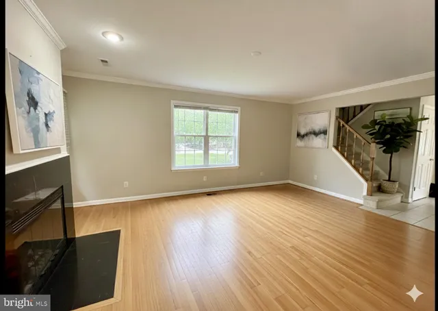 a view of a livingroom with wooden floor and a window