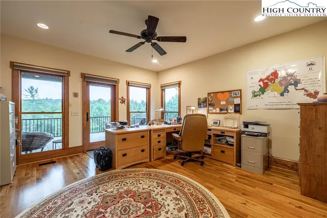 a living room with furniture a rug and a floor to ceiling window