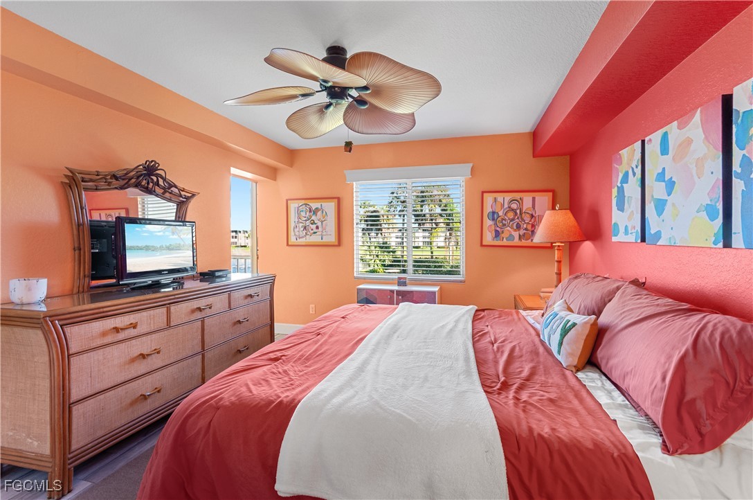 20121 Ian Court, Unit 209 Estero, FL 33928 - Photo 13 of 40 a bedroom with a bed and a flat screen tv