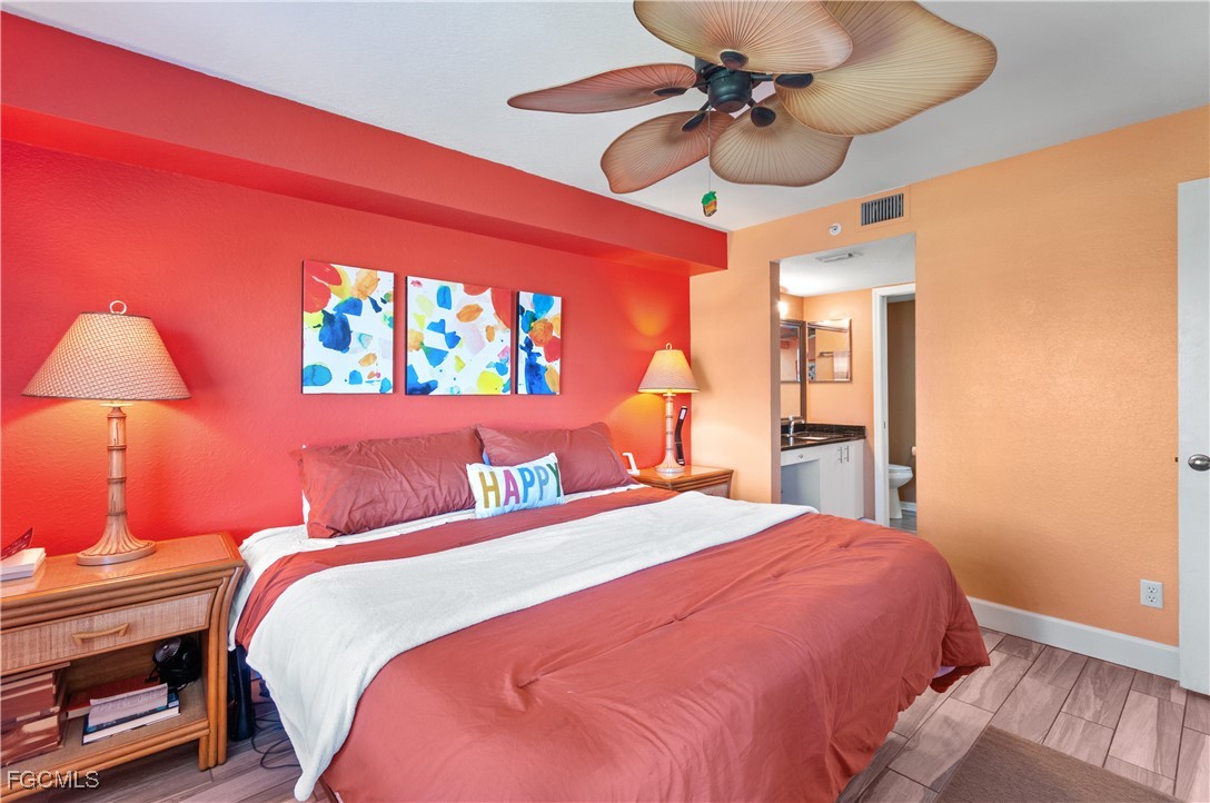 20121 Ian Court, Unit 209 Estero, FL 33928 - Photo 14 of 40 a bedroom with a bed and a chandelier