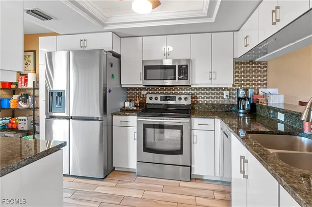 a kitchen with stainless steel appliances granite countertop a refrigerator stove and sink
