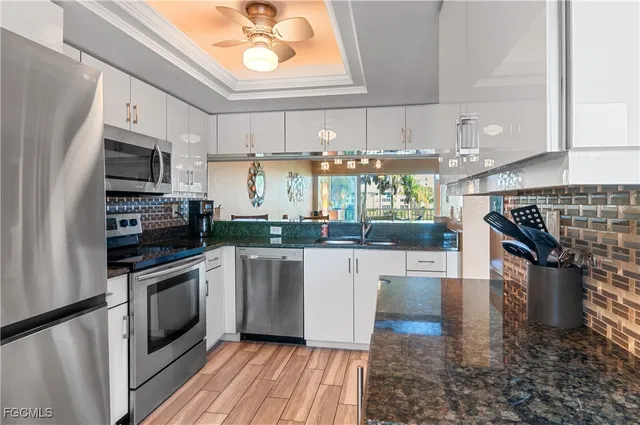 a kitchen with stainless steel appliances kitchen island granite countertop a stove a sink and a microwave