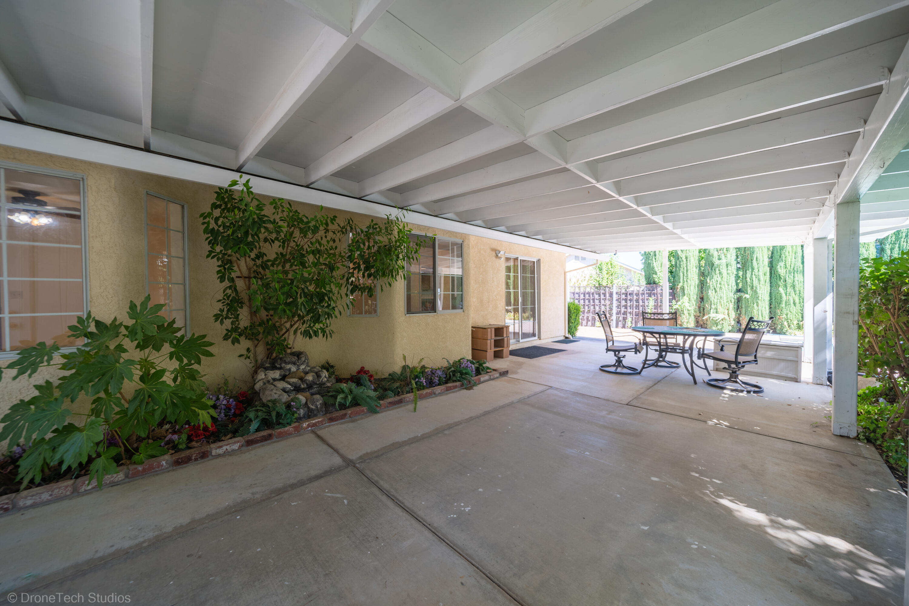 2227 Wicklow Street Redding, CA 96001 - Photo 36 of 90 a view of a patio with table and chairs potted plants and floor to ceiling window