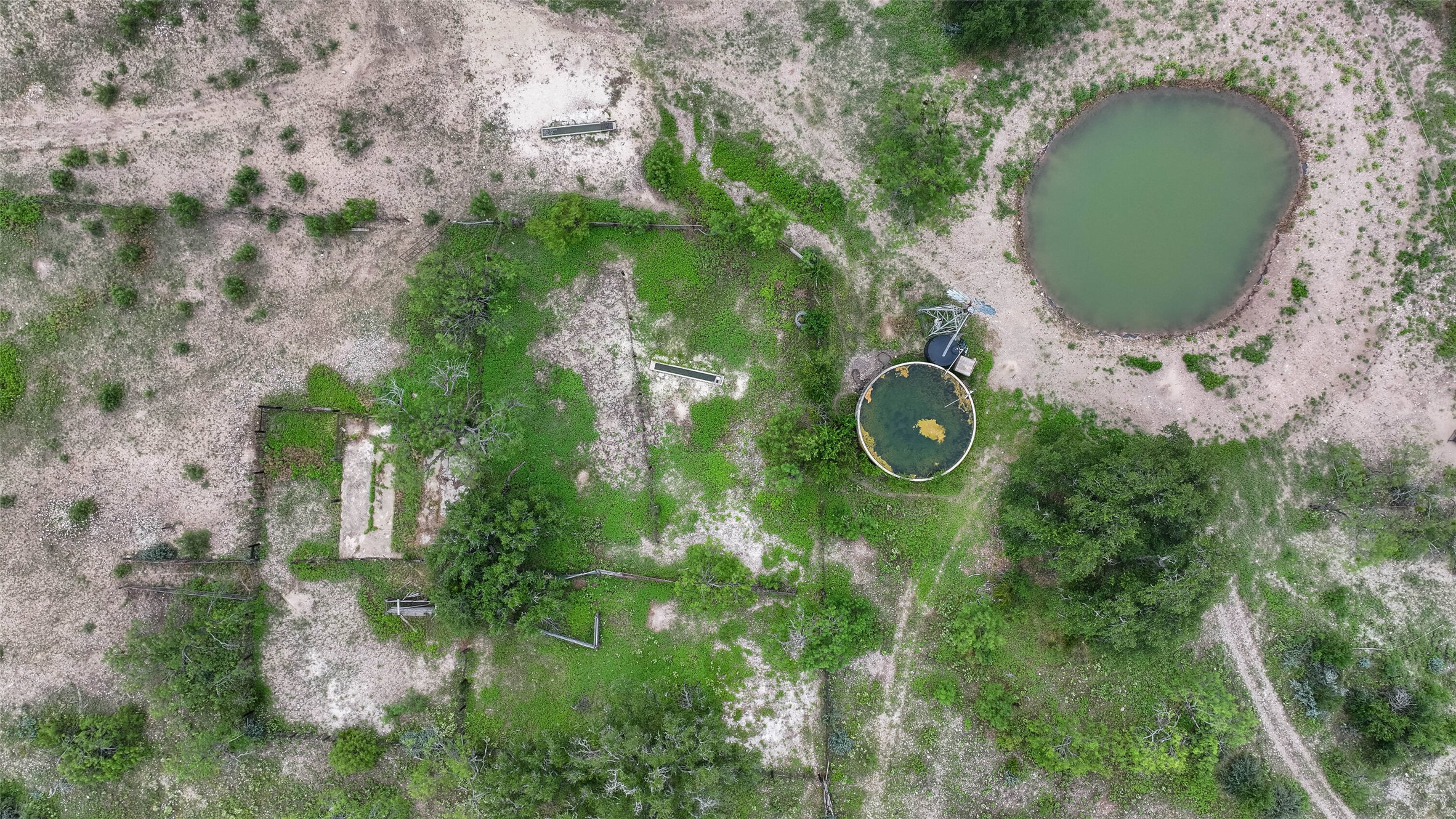 5 Dominion At Oak Ridge Junction, TX 76849 - Photo 19 of 34 Aerial perspective showcasing an irregular-shaped pond, a circular water tank, and several concrete pads
